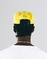 Gorra amarilla con visera curva, con logo de un caballo salvaje y texto "TwoJeys" bordado en negro.