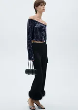 Blusa azul marino con lentejuelas, hombros descubiertos y mangas largas acampanadas.