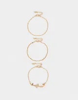 Set de tres pulseras doradas para mujer. Una pulsera es de cadena fina, otra con cuentas pequeñas y la tercera con dijes de mariposas.
