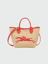 Bolso Longchamp modelo Le Panier Pliage, de paja color beige con detalles en cuero rojo, incluyendo asas y ribetes. Presenta un bordado de un caballo en rojo.