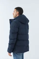 Campera puffer azul marino para hombre, con capucha ajustable, cuello alto, bolsillos con cierre y logo en goma.