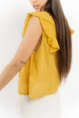 Blusa blanca de algodón con escote en V, volados en el frente y mangas cortas.