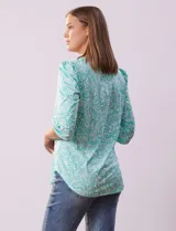 Blusa estampada color beige con cuello redondo calado y mangas 3/4 abullonadas con terminación elastizada.