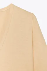 Camiseta color beige de lino con cuello en V y mangas cortas.