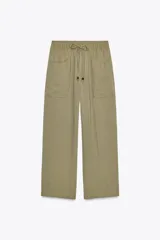 Pantalón color verde oliva de tiro alto, corte ancho y largo 7/8. Tiene cintura elástica ajustable con cordón, bolsillos de plastrón en delantero y espalda.