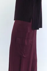 Pantalón cargo de seda color terracota, con corte ancho y bolsillos laterales.