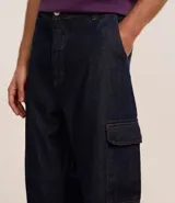 Pantalón de jean azul oscuro, modelo baggy, con bolsillos cargo laterales y cintura con trabillas.