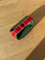 Neceser color beige de forma rectangular, con cierre superior y asa de mano.