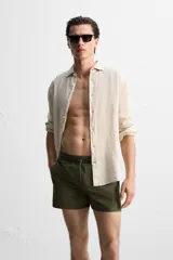 Short de baño negro de tejido técnico, con cintura elástica ajustable con cordón, bolsillos laterales y bolsillo trasero.