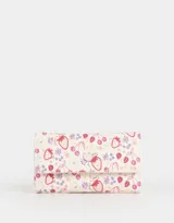 Billetera de cuerina con estampado de flores, fresas y cerezas. Tiene formato de fichero con solapa y broche en forma de corazón. Cuenta con compartimentos para tarjetas y billetes.