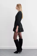 Vestido corto color violeta, de escote cruzado con volados, mangas largas abullonadas y cintura elastizada. Confeccionado en jacquard con corazones.