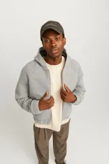 Campera gris melange con capucha, cierre frontal con cremallera, bolsillos laterales y puños elásticos.