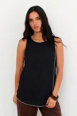 Musculosa negra con cuello redondo y ribete color crema en cuello, sisas y ruedo.