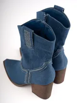 Botas texanas de denim azul con bordados y apliques de strass. Taco de madera y puntera cuadrada. Cierre lateral con cremallera.