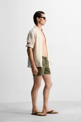 Short de baño negro de tejido técnico, con cintura elástica ajustable con cordón, bolsillos laterales y bolsillo trasero.
