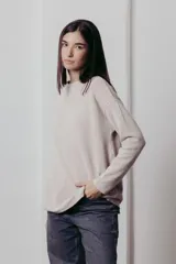 Sweater color crema de tejido de punto con hilos metalizados, corte relajado, hombros caídos y terminaciones clásicas.