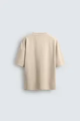 Camiseta color beige de corte holgado, cuello redondo y manga corta.