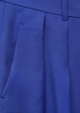Pantalón de vestir azul eléctrico, de corte wide leg, tiro alto y diseño largo. Presenta cierre delantero con botón, gancho y cremallera ocultos, trabillas para cinturón, pinzas delanteras y bolsillos laterales.