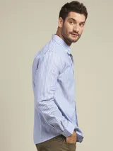 Camisa de corte clásico color azul con bolsillo en el pecho y cierre frontal con botones.