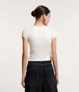Blusa blanca de poliamida con cuello redondo y mangas cortas.