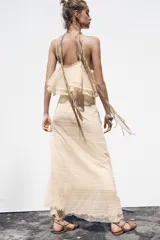 Vestido midi color crema de punto pointelle con tirantes finos y volantes en el escote.