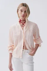 Camisa de tela de algodón color rosado, con cuello y puños con volados en diseño rayado.