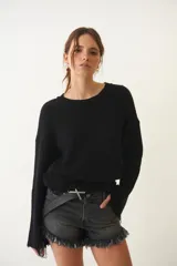 Short de jean negro con tiro bajo, efecto desgastado y flecos en el ruedo.