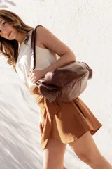 Bolso bandolera color marrón de cuero sintético con correa ajustable y bolsillo externo con cierre.