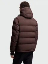 Campera puffer de esquí Moncler Grenoble modelo Isorno, color marrón oscuro. Presenta diseño acolchado, capucha integrada, cierre frontal impermeable, bolsillos laterales con cremallera y puños elásticos con abertura para el pulgar. Incluye el logotipo de la marca en el pecho.