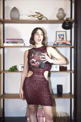 Vestido corto tejido a mano con hilado de lentejuelas color borgoña, acordonado en la espalda y con aberturas en las caderas.