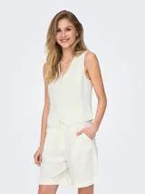 Chaleco sastrero color blanco hueso con bolsillos delanteros. Confeccionado en tejido plano de viscosa y lino. Diseño con cierre de botones y detalle adicional en el frente.