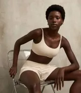 Top deportivo color marrón con breteles anchos y doble tira, copa desmontable, detalles contrastantes en color crema, escote en U delantero y escote en V en la espalda. Confeccionado en microfibra.