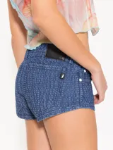 Mini short de tiro bajo, súper corto, color azul. El denim tiene una textura con relieve y desgastes.