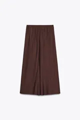 Falda midi color ocre de tejido arrugado con cintura elástica ajustable con cordones y bolsillos laterales ocultos en la costura.