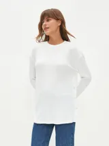Remera blanca de tejido acanalado, con cuello redondo y mangas largas.