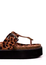 Sandalias con estampado animal print, con tira entre los dedos y plataforma flatform con base negra.