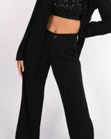 Pantalón sastrero negro de corte ancho, con bolsillo frontal y cierre de botón.