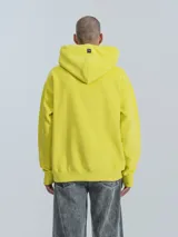 Hoodie amarillo neón de frisa premium con capucha ajustable, corte oversize, cintura y puños elastizados.