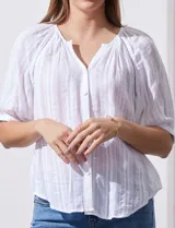 Blusa blanca de algodón marca Zac & Rachel, con cuello a la base, escote en V, abertura central con botones y sisa con aplique calado.