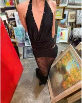 Top negro con escote halter profundo y detalle de tachas plateadas.