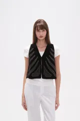 Chaleco negro de terciopelo con escote en V y bordados en hilo plateado que simulan formas orgánicas o de huesos.