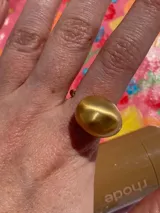 Anillo plateado de metal con forma redondeada y diseño chunky.