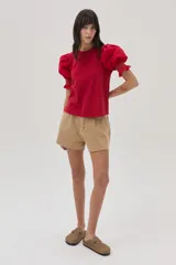 Blusa roja de algodón con mangas cortas abullonadas y puños con detalle de bordado en color amarillo/naranja.