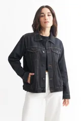 Campera de jean azul con cuello clásico, cierre frontal con botones metálicos, bolsillos con solapa abotonada en el pecho y bolsillos laterales.