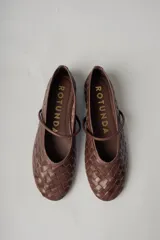 Chatitas de cuero marrón con diseño tejido y tira sobre el empeine.