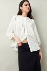 Falda midi de denim negro con tiro bajo, corte evasé, costuras verticales y ruedo desflecado.