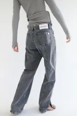 Pantalón de jean azul de corte recto y tiro medio, con lavado desgastado, pespuntes en rojo y deshilachado en la pretina.