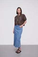 Blusa con estampado animal print en blanco y negro, de mangas cortas abullonadas y cuello redondo.