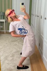 Túnica de lino a rayas verticales color lila y blanco, con cuello polo y bordado de un pulpo azul en el frente.