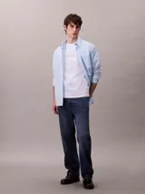 Remera blanca de algodón regenerativo con cuello redondo, corte regular y mangas cortas. Presenta el logotipo de Calvin Klein bordado en el frente.